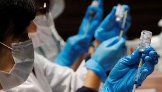 عاملة صحية تعد جرعة من لقاح كورونا