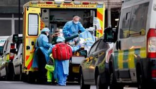 نقل مصاب بكورونا لسيارة الإسعاف ببريطانيا- أرشيفية