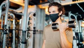 شاب يرتدي كمامة في صالة للألعاب الرياضية