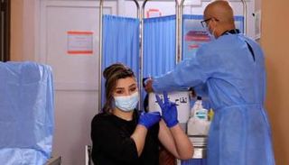 سيدة تحصل على لقاح كورونا في العراق - أرشيفية