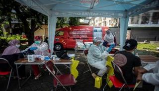 أشخاص يتلقون لقاح كورونا في جاكرتا