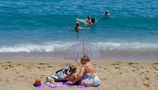 سيدة وطفلها على الشاطئ في برشلونة بعيدا عن قيود كورونا