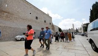 سائحون أجانب يسيرون أثناء زيارتهم لكنيسة المهد في بيت لحم 