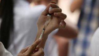 عاملة صحية تعد جرعة من لقاح كورونا