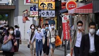 أشخاص يرتدون كمامات للوقاية من كورونا في اليابان