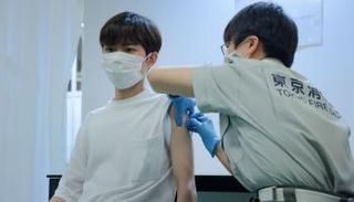 شاب يتلقى لقاح كورونا في طوكيو