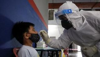 عامل صحي يأخذ مسحة من طفل