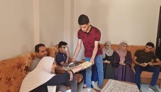 أحد التوائم يوزع حلويات التفوق