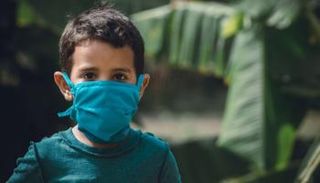 طفل يضع الكمامة خلال سيره في الشارع