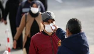 كادر طبي يطمئن على درجة حرارة مواطن مغربي - صورة أرشيفية