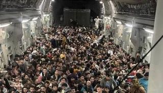 الأفغان بداخل طائرة النقل العسكرية التي أقلعت من مطار كابول الأحد