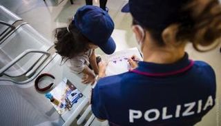 إحدى الشرطيات الإيطاليات ترسم مع طفلة أفغانية