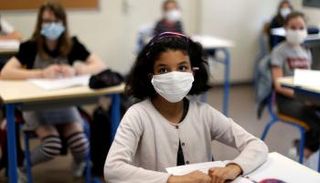 طالبات يضعن الكمامة داخل الفصل الدراسي