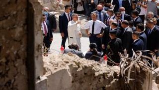 ماكرون وسط الدمار الذي خلفه داعش بالموصل - الفرنسية