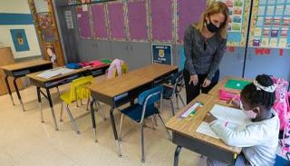 معلمة وتلميذة في صف دراسي (أرشيفية)