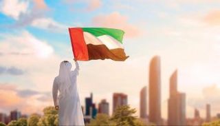 شاب يحمل علم الإمارات