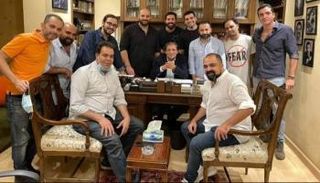 خالد يوسف في مكتبه وسط عدد من أصدقائه