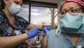 سيدة تحصل على لقاح كورونا