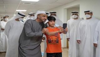 الشيخ محمد بن زايد آل نهيان خلال التقاط صورة مع طفل أفغاني