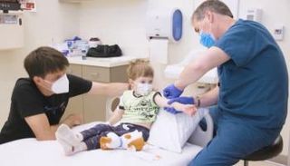 طبيب يكشف على طفل مصاب - أرشيفية