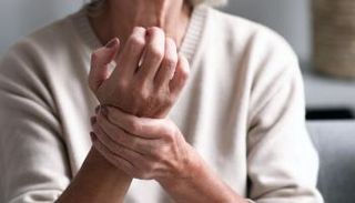 سيدة تتألم من الروماتويد وتمسك برسخها 