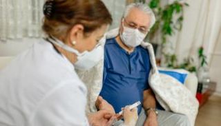 دكتورة تقيس مستوى السكر في دم مريض