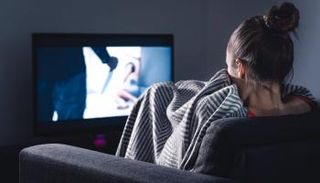 فتاة مذعورة تشاهد أحد أفلام الرعب (صورة تعبيرية)