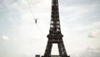 صور: مغامر يمشي 600 متر على حبل.. استعراض باهر من برج إيفل