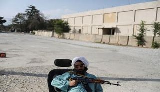 جندي من طالبان على كرسي في قاعدة باغرام الجوية