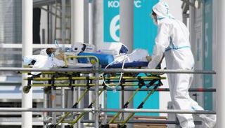 عامل صحي ينقل مريضا بكورونا في روسيا (أرشيفية)