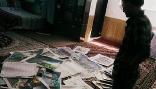 فنان ينظر للوحات فنية استعادها من منشأة تديرها الحكومة - واشنطن بوست