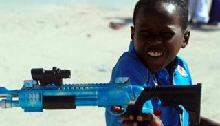 طفل صومالي يحمل رفيقه لعبة سلاح- أرشيفية