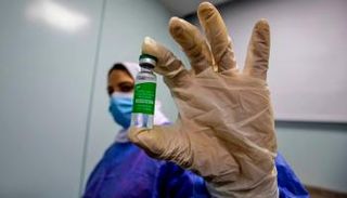 عاملة صحية في مصر تمسك بإحدى جرعات لقاح كورونا