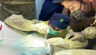 رجال الدفاع المدني خلال تحرير يد الطفلة من المفرمة