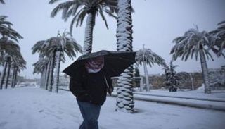 مواطن عراقي يسير وسط تساقط الثلوج - أرشيفية