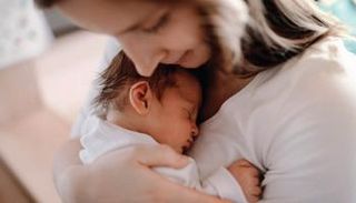 أم تحتضن طفلها الرضيع