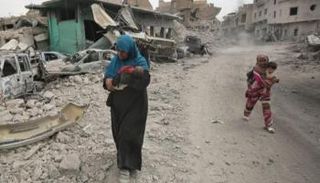 امرأة موصلية برفقة أطفالها عند المدينة القديمة - أرشيفية