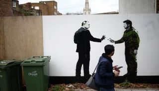 شخص يمشي أمام لوحة تصور الرئيسين بوتين وزيلينسكي في لندن - رويترز