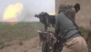 أحد الدواعش في سوريا يثبت سلاحه الرشاش على دراجة نارية- أرشيفية