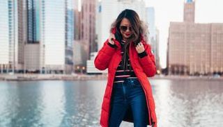 المعطف الأحمر يمنح المرأة إطلالة جريئة - أرشيفية