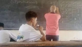 طالب يشعل سيجارة داخل الفصل 