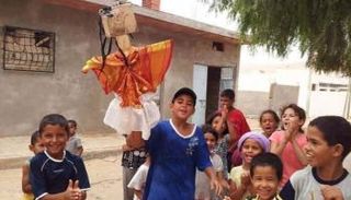 أطفال يحملون دمية "أمك طنقو"