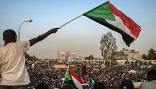 متظاهر يحمل علم السودان