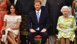 الأمير هاري يتوسط الملكة الراحلة إليزابيث وزوجته ميجان