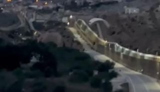 لحظة عبور المهاجر السياج بالمظلة الشراعية