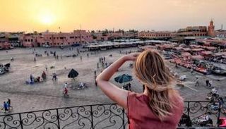 سائحة أجنبية تطل على ساحة جامع الفنا بمراكش - أرشيف