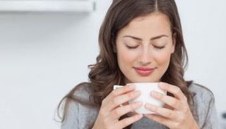 سيدة تستمتع برائحة مشروبها