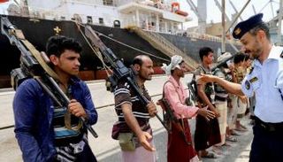 عناصر حوثية تحمل الأسلحة في ميناء الحديدة