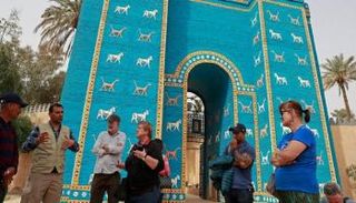سياح أجانب قرب مجسم لبوابة عشتار في مدينة بابل الأثرية - أ.ف.ب