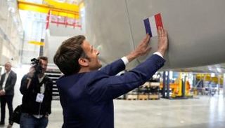  إيمانويل ماكرون يضع ملصقا لعلم بلاده